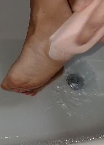 Herrinen Füße mit Bimsstein unter der Dusche
